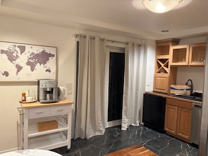 A compact kitchen with a coffee machine, a sink, and wooden cabinets. - "Your Cozy Kirkland Getaway Awaits – Comfort and Charm Combined" (Kirkland)