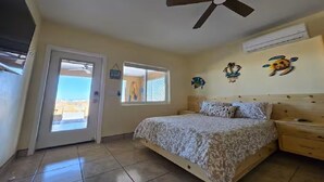 A bedroom with a bed, a ceiling fan, a window, and a door. - Casita Sol en el Dorado Rach para parejas/Starlink Wifi/Spa (B.C.)