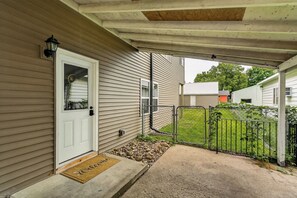 A residential property with a covered porch, a white door, and a metal gate.