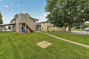 A residential property with a sloped roof, a front yard, and a tree.