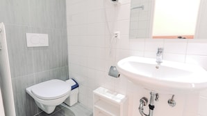 Un baño con inodoro, lavabo y ducha.