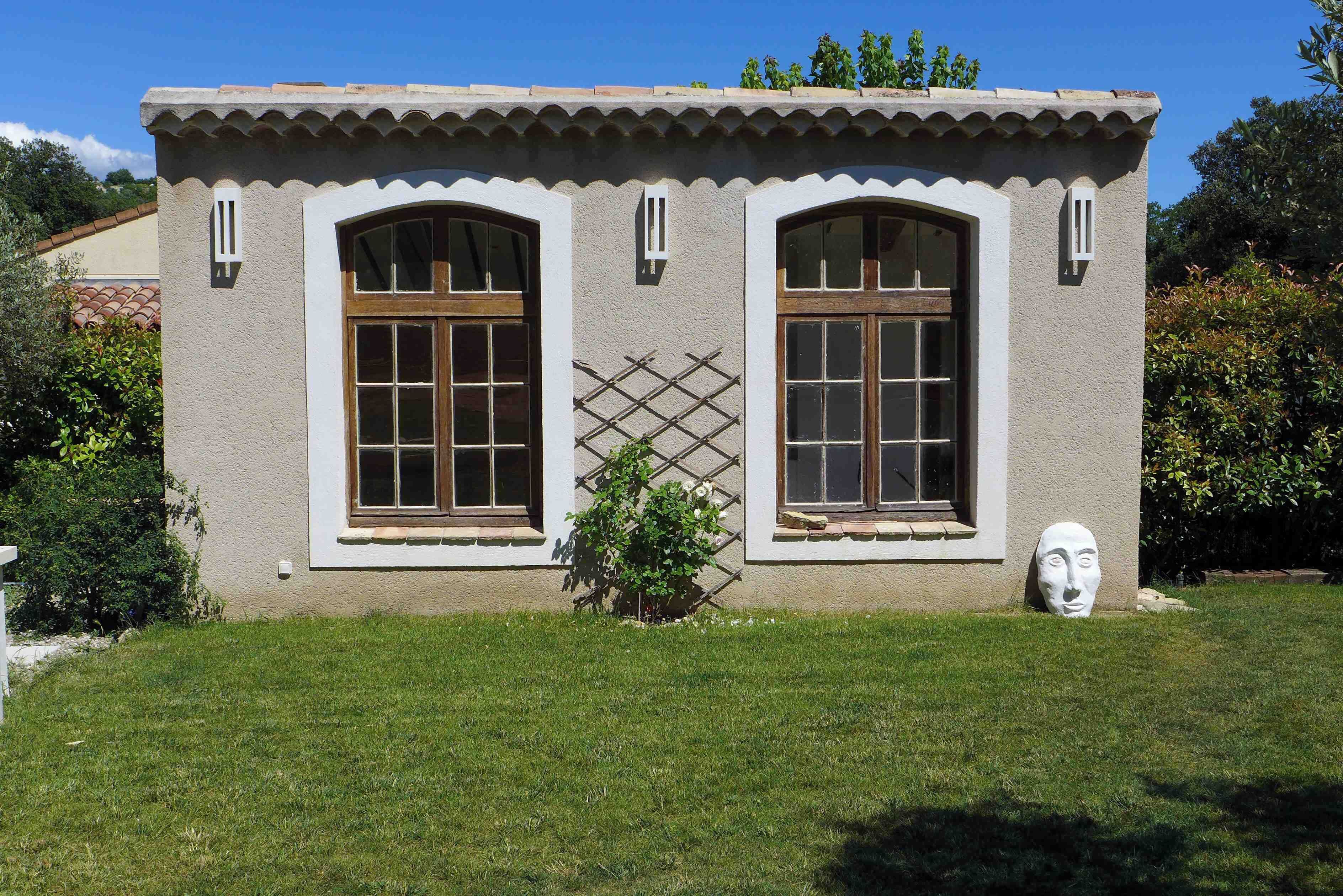 Un bâtiment à deux étages, doté de fenêtres en arc de cercle et d’un toit recouvert de tuiles.