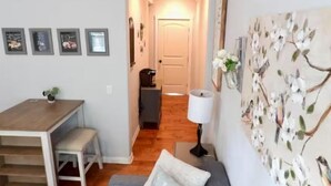 Un apartamento moderno con comedor, un sofá y una pared con un mural floral.