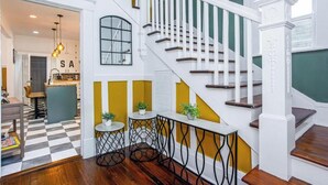 A staircase with white railings and wooden steps, leading to a landing with a view of a kitchen area. - Near Starland, River St & DT - Gaming Arcade - Large Yard (Savannah)