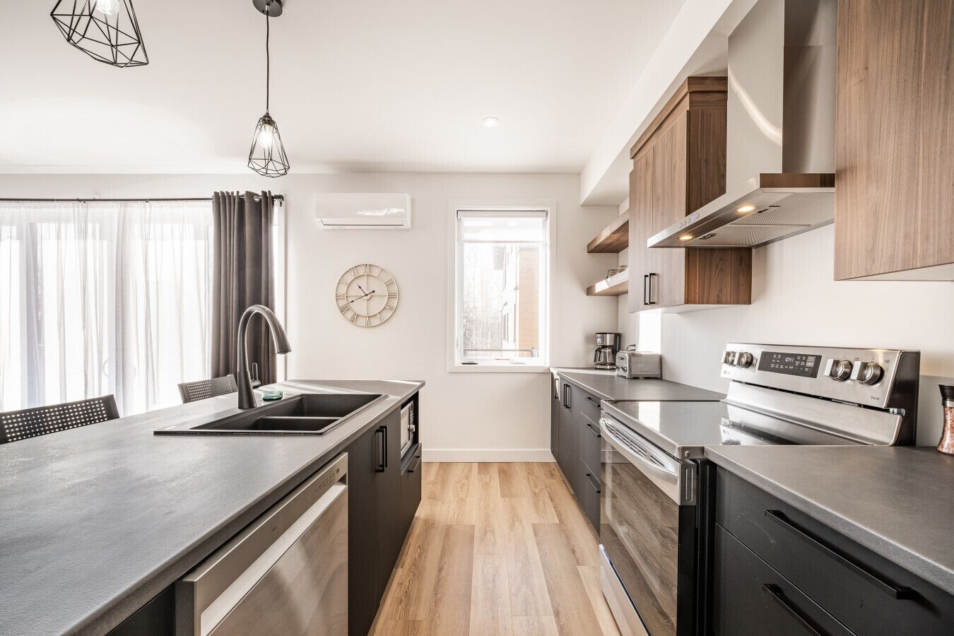 A modern kitchen with a central island, stainless steel appliances, and wooden cabinetry.