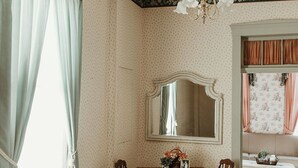 Ein Esszimmer mit einem Holztisch, Stühlen, einer Kristallleuchter und einem großen Spiegel.