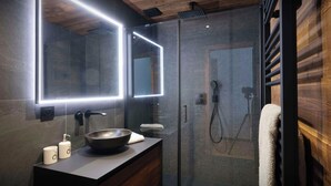 A modern bathroom with a glass shower enclosure, a wooden vanity, and a large mirror with LED lighting.