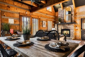 A wooden dining room with a fireplace, black chairs, and a table set for four. - Million$View,New,Hot Tub,Pool Table,Game (Seviervill)