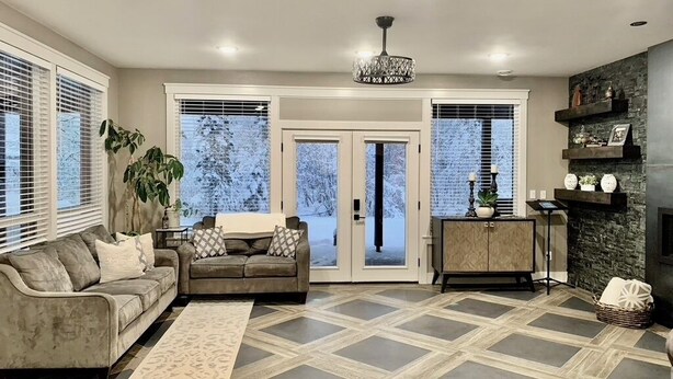 A living room with a sofa, a coffee table, a rug, and a fireplace.