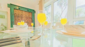 A dining table with plates, glasses, and cutlery, and a green door in the background. - 6BR Mansion With Games Room & Hot Tub (Cardiff)