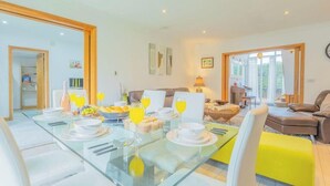 A dining area with a glass table, chairs, and a breakfast setting. - 6BR Mansion With Games Room & Hot Tub (Cardiff)