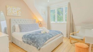 A bedroom with a bed, bedside table, chair, and window. - 6BR Mansion With Games Room & Hot Tub (Cardiff)