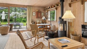 Ein Holzinnenraum mit Kamin, Essbereich und Terrasss.
