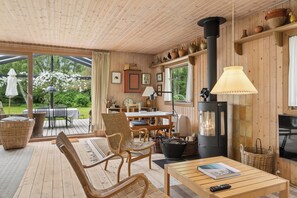 Een houten interieur met een open haard, een eethoek en een terras.