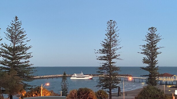 A coastal view with a boat, trees, and a pier. - Coastal stay with great views (Redcliffe)