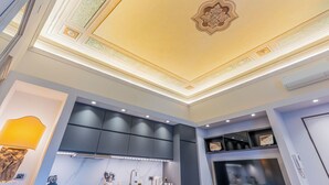 Une cuisine moderne dotée de meubles encastrés, d’un pare-feu en marbre et d’un plafond décoratif.