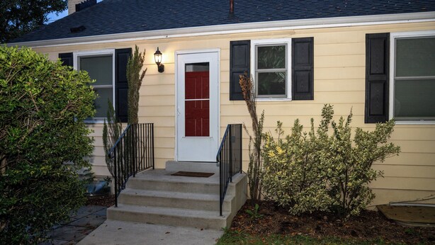 A two-story house with a red door, a front porch, and a small garden. - Private Basement Suite Near Metro, See the Best of Silver Spring (Silver Spring)