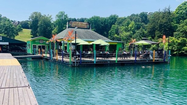 Ein Restaurant am Wasser mit Terrassensitzplätzen und einem Steg.