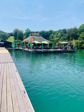 Ein Restaurant am Wasser mit Terrassensitzplätzen und einem Steg.