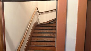 Un escalier en bois, doté d’une rampe et d’une porte en bas.