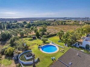 Una propiedad residencial con piscina, un patio y vistas del paisaje circundante.