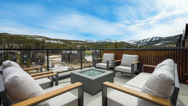 A balcony with outdoor seating, a fire pit, and a mountain view. - Downtown WP Loft 57 I Rooftop Hot Tub & Lounge I Great Views I Bunk Room I Discounted Attractions (Winter Park)