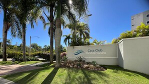 Skilt for Casa Club Mediterráneo med en velplejet græsplæne og palmer.
