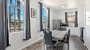 A modern kitchen with white cabinets, a stainless steel refrigerator, and a microwave.
