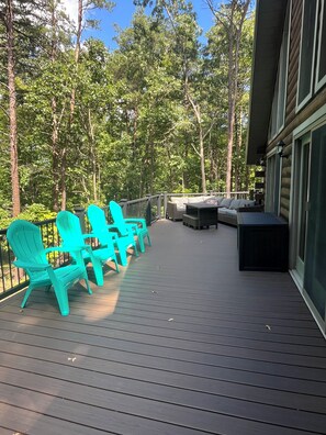 A deck with outdoor seating, surrounded by trees. - The Hawn Hideaway-3 mi to Seven Points Marina, sleeps 12 (Hesston)