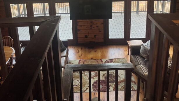 Un interior de madera con chimenea, ventanas amplias y una cabeza de venado montada en la pared.