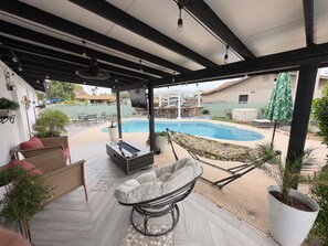 A covered patio with a pool, outdoor furniture, and a hammock. - 3-bedroom house in nice Phoenix with cool AC (Phoenix)