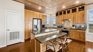 Une cuisine moderne avec des meubles en bois, un îlot central et des appareils électroménagers intégrés.