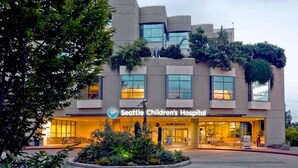 El edificio del Hospital Infantil de Seattle, con un diseño moderno, ventanas amplias y un cartel que indica la entrada.