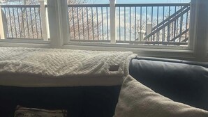 A view through a window of a lake, mountains, and a railing. - Lakefront Retreat w/ Private Dock & Beach Access (McCall)