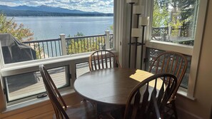 Un espace repas avec vue sur un lac et des montagnes.