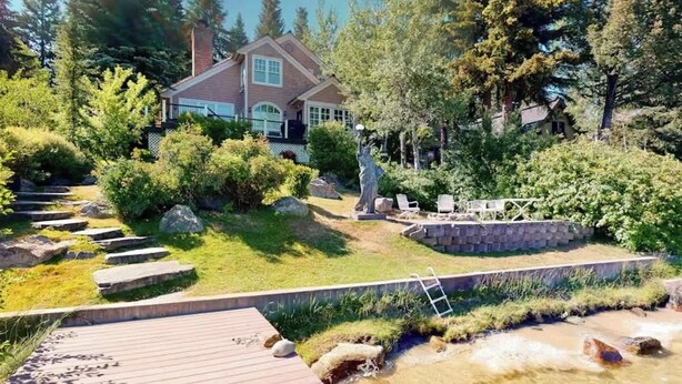 A house with a garden, a wooden deck, and a stone wall. - Lakefront Retreat w/ Private Dock & Beach Access (McCall)