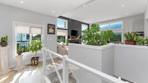 A modern interior with a balcony, potted plants, and a view of the outside. - Westcoast Kaatza All Day Sun (Lake Cowichan)