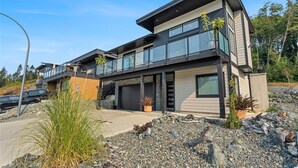 A modern two-story house with a garage, large windows, and a balcony. - Westcoast Kaatza All Day Sun (Lake Cowichan)
