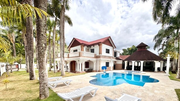 A large house with a swimming pool, lounge chairs, and palm trees. - Tremendous 6-bedroom villa with AC in peaceful Samana (Samana)
