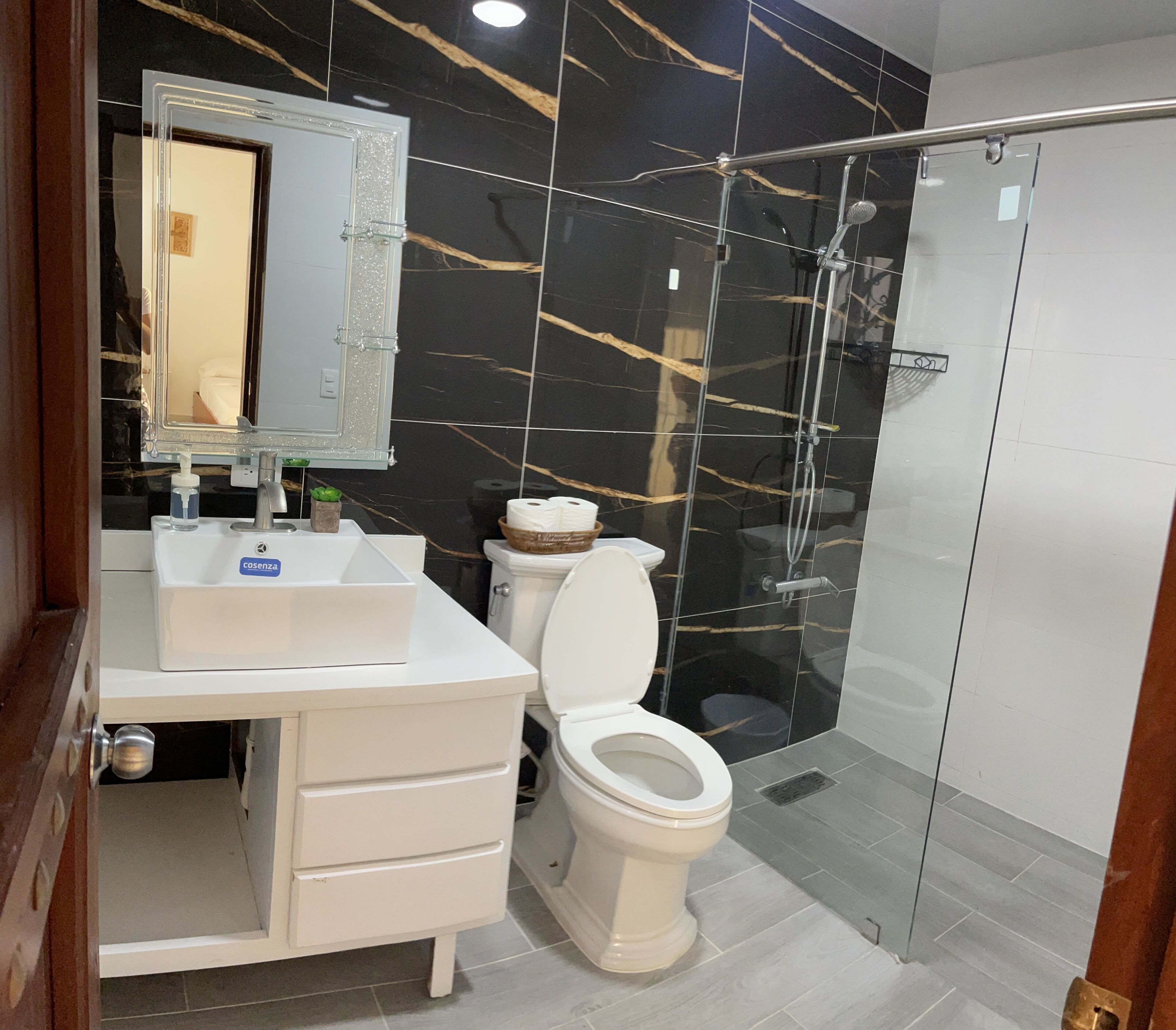 A bathroom with a white sink, a toilet, and a glass-enclosed shower.