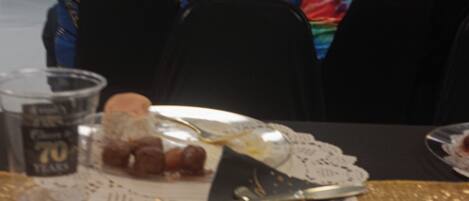A dining table with a plate of food, a glass of water, and a cupcake.