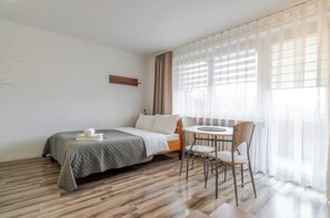 Une chambre d’hôtel avec un lit, une petite table ronde et une chaise.