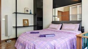 Un dormitorio con cama, armario, estante con adornos y espejo.