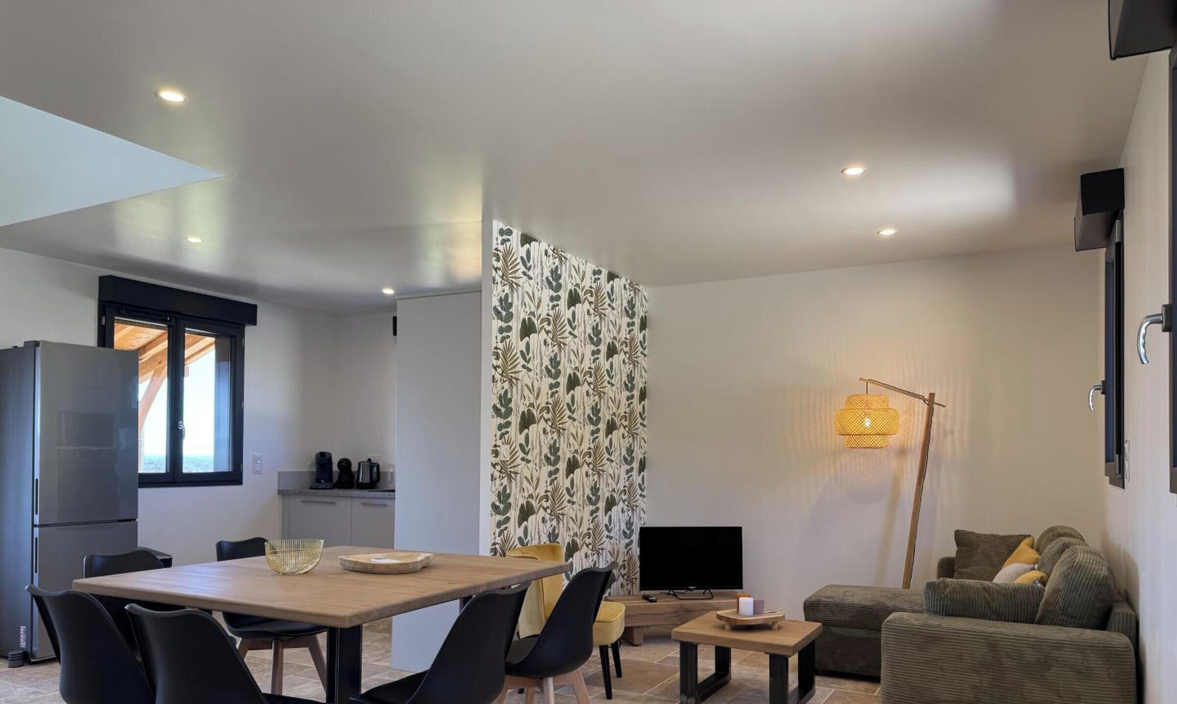 Un ambiente moderno con zona pranzo, cucina e angolo relax.