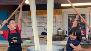 Two children in aprons hanging strips of dough from a pot. - Chalet with terrace - 4 guests (Naucelle)