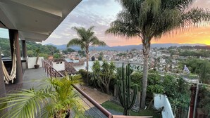 A balcony with a view of a cityscape and mountains during sunset. - Casa con jacuzzi y vista en Valle de Bravo (Valle de Bravo)