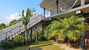 A modern building with a concrete staircase, palm trees, and a clear sky. - Casa con jacuzzi y vista en Valle de Bravo (Valle de Bravo)