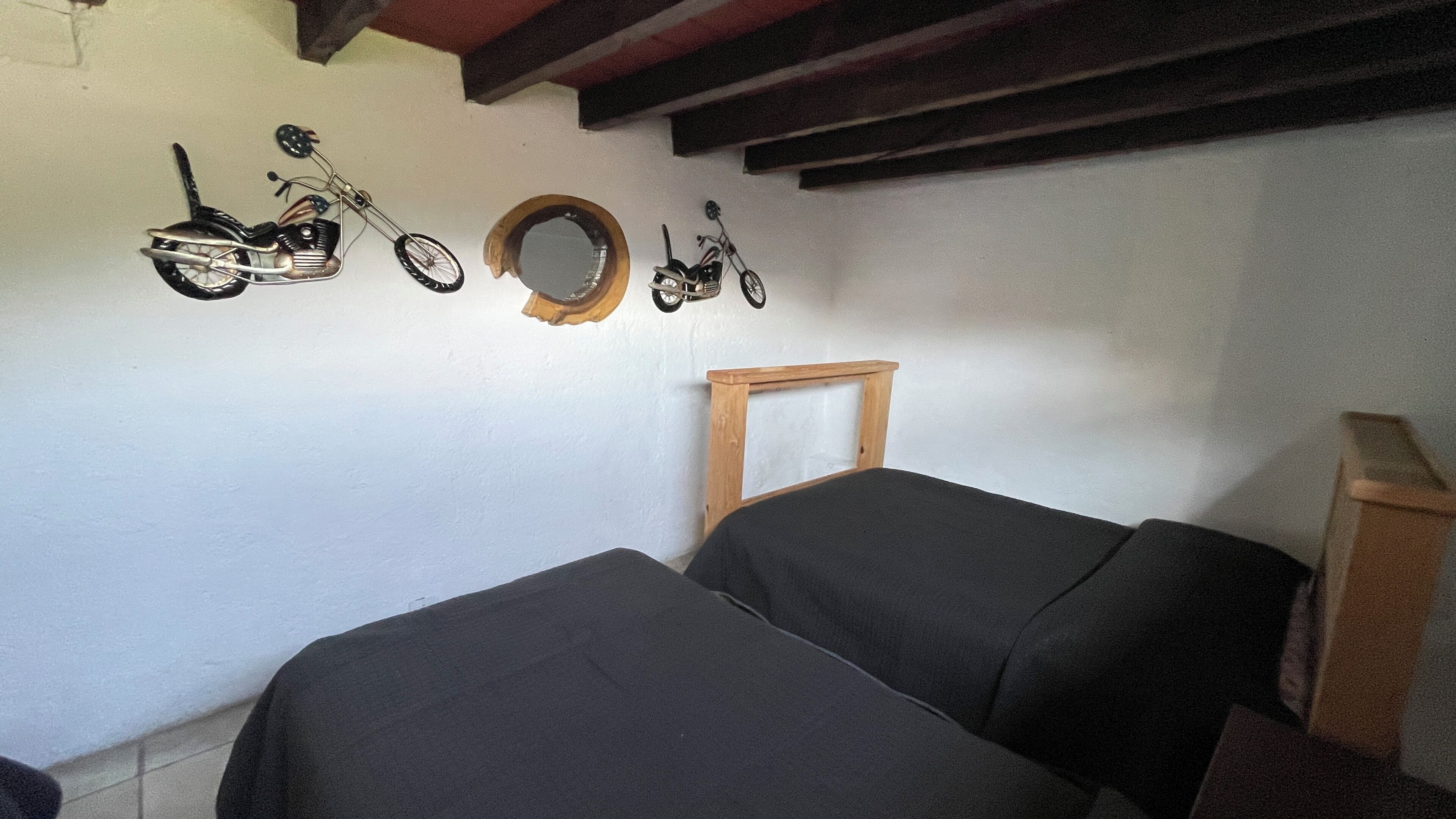 A room with two beds, a wooden bench, and wall-mounted bicycles.