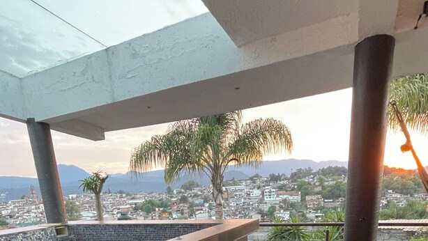 A rooftop terrace with a hot tub, wooden steps, and a view of a cityscape. - Casa con jacuzzi y vista en Valle de Bravo (Valle de Bravo)