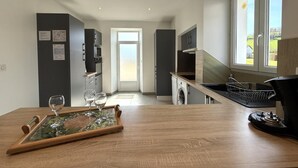 Une cuisine moderne avec un coin repas, un lave-linge et une vue sur l’extérieur.